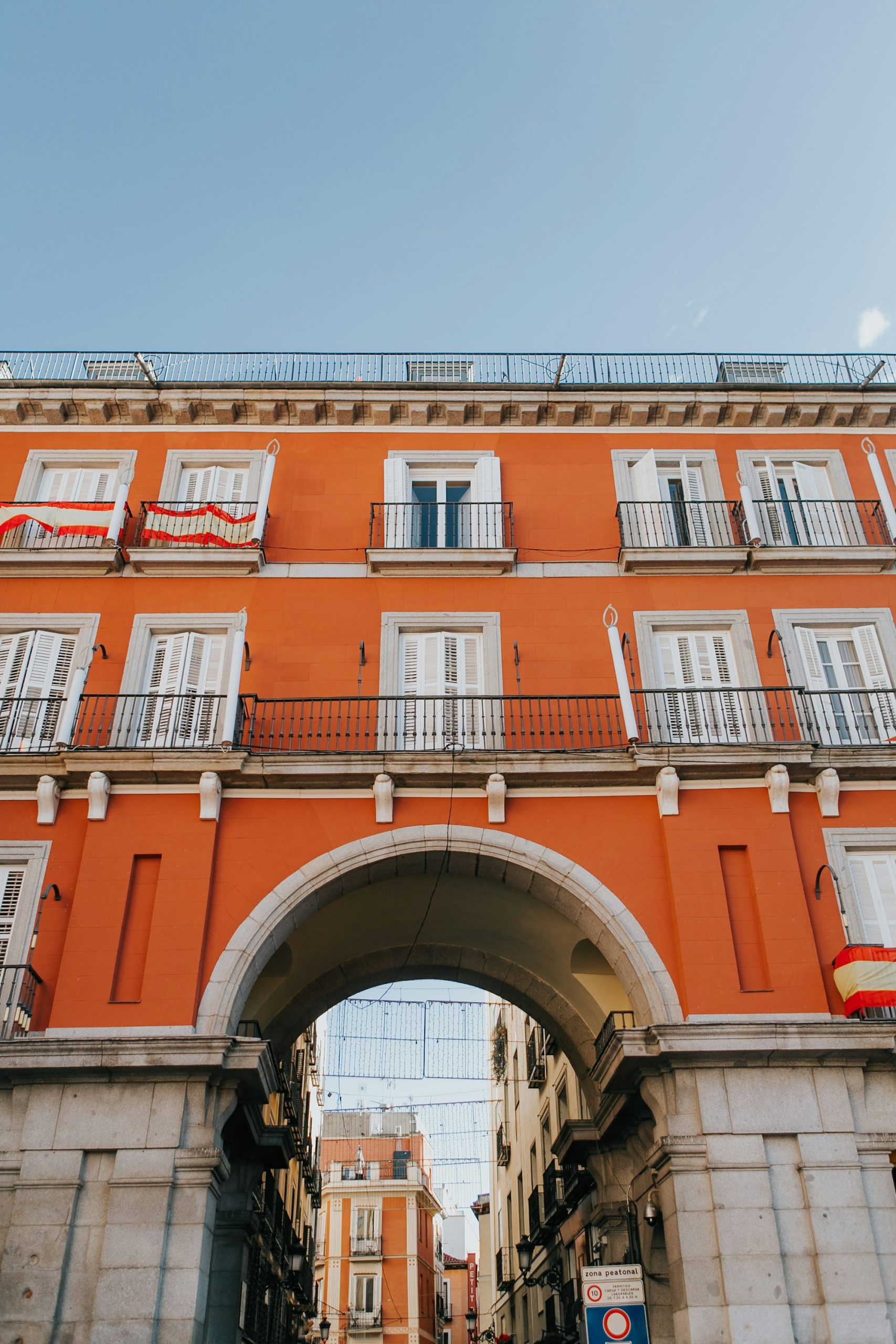 Fachada de un edificio histórico de viviendas con balcones y un arco de piedra